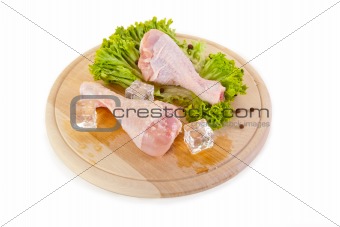 Fresh and frozen chicken legs on chopping board 