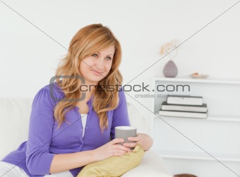 Pretty red-haired woman posing and enjoying the moment while sit
