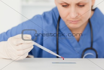 Cute female scientist preparing a microscope slide