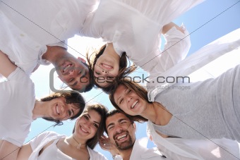 Group of happy young people in circle at beach
