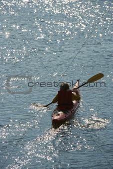 Boy paddling kayak.