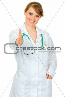 Smiling medical doctor woman stretches out hand for handshake

