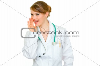  Smiling medical doctor woman holding her hand near mouth and secretly reporting good news
