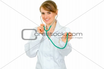 Smiling medical female doctor holding up stethoscope
