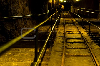 Railway in abandoned mine with yellow lights