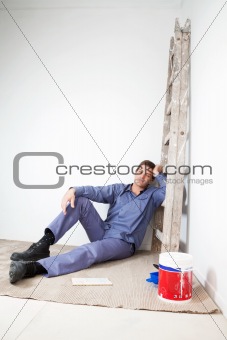 Thoughtful mature man sitting on floor