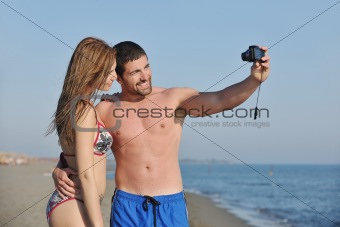 happy young couple in love taking photos on beach