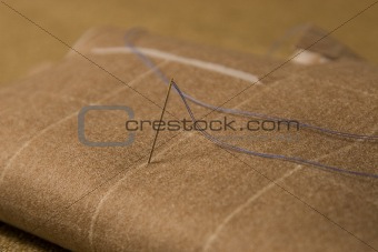needle and thread on fabric background