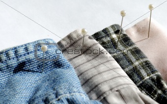 Different textures and colors of clothes with pins