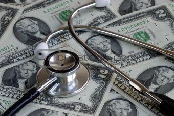 A stethoscope on the top of some two dollar bills
