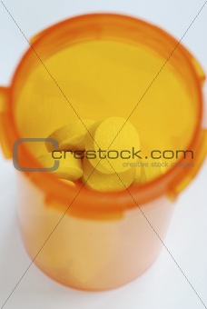 The medicine bottle with some yellow pills