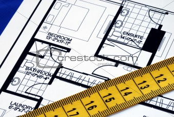 Measure the floorplan with a  measuring tape isolated on blue
