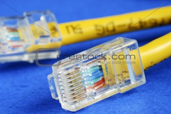 Close-up view of the yellow Ethernet (RJ45) network cable isolated on blue