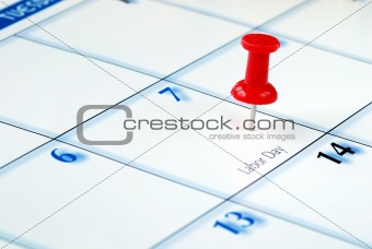 A red pin nailed in the business calendar
