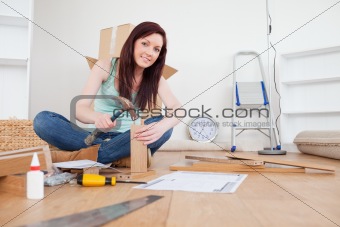 Beautiful red-haired female nailing a plank at home