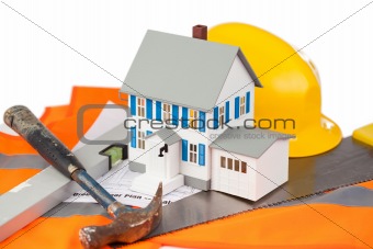 Tools and miniature house on an orange jacket