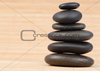 Black stones stack against bamboo background