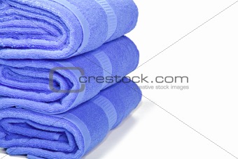 Three blue towels on a white with space for text