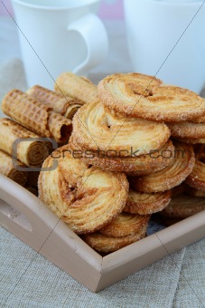 Assorted cookies, puff and waffle in a wooden bowl