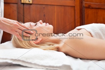 Young blond woman receiving head massage
