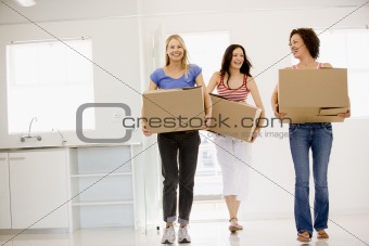 Three girl friends moving into new home smiling