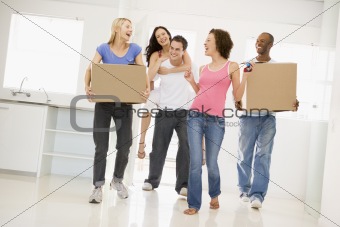Group of friends moving into new home smiling