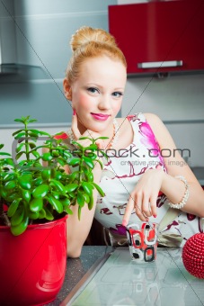 blond girl with glass in interior of kitchen