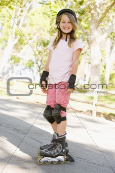 Young girl outdoors on inline skates smiling