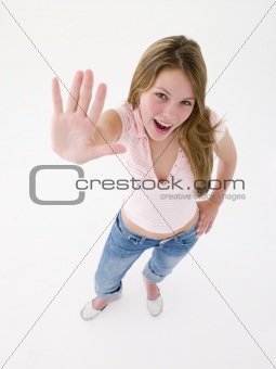 Teenage girl with hand up smiling