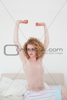 Attractive blonde female stretching in her bedroom