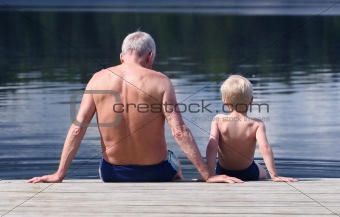 Grandfather and Grandson sitting on a footbridge