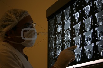 Doctor in surgical scrubs looking x-ray