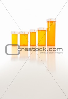 Several Different Sized Empty Medicine Bottles as Increasing Graph on Reflective Surface.