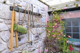 garden tools on stone wall