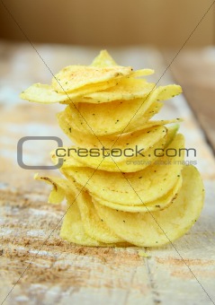 pile of ruffled potato chips  on a wooden table