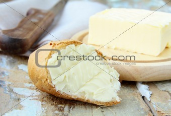 fresh yellow butter and fresh bread on a wooden table