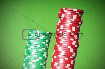 Stack of red and green casino chips against green background