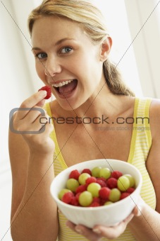 Young Woman Eating A Bowl Of Fruit
