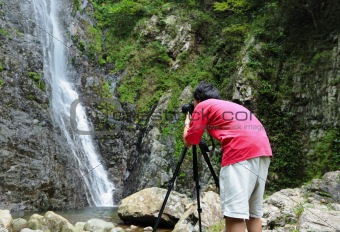 photographer taking picture of waterfall