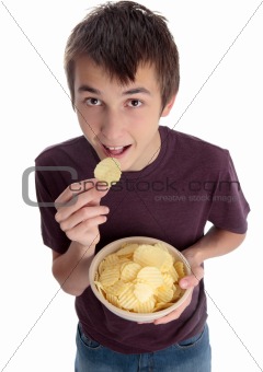 Boy eating chip snack and looking up