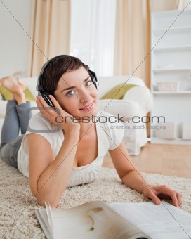 Portrait of a smiling woman with a magazine enjoying some music