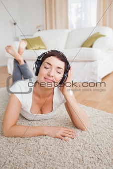 Portrait of a delighted brunette listening to music