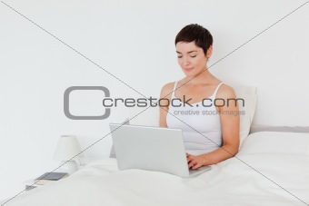 Charming brunette using a laptop