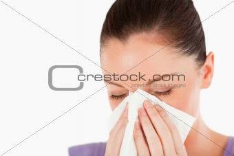 Portrait of an attractive woman sneezing while standing