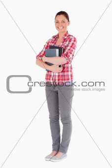Attractive female posing with books while standing