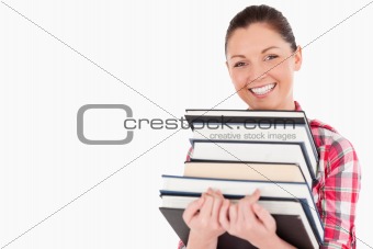 Gorgeous female posing with books while standing