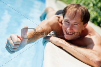 Young man showing  a thumbs up near swimmingpool