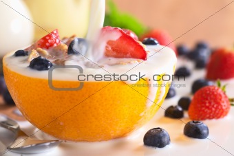 Pouring Milk Over Wholewheat Cereal with Fresh Fruits