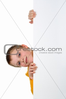 Small boy looks out of blank billboard with his head tilted to the side isolated on white