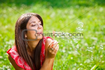 Beautiful woman blowing soap bubbles